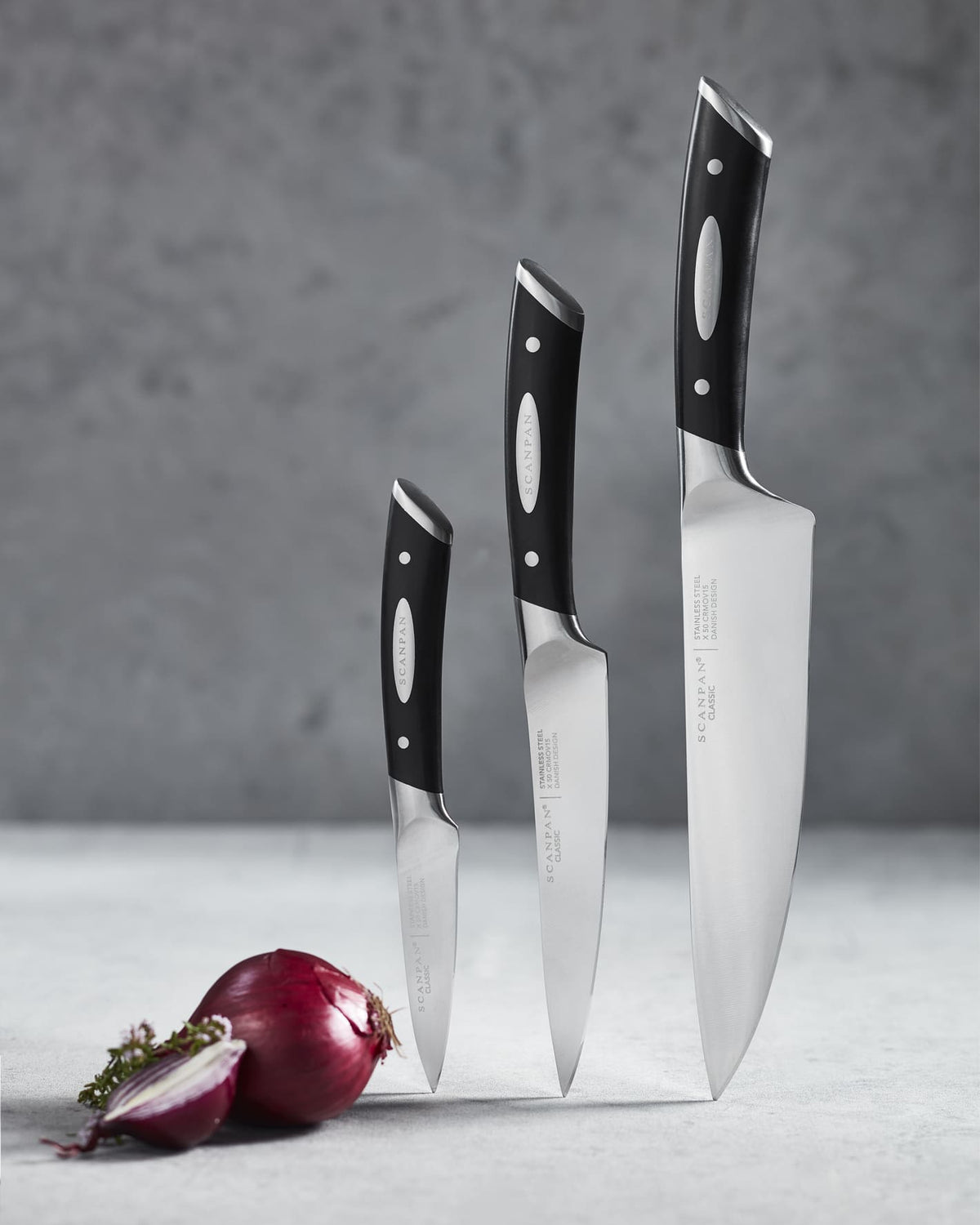 Three knives from the SCANPAN Classic chef’s knife set on a kitchen worktop