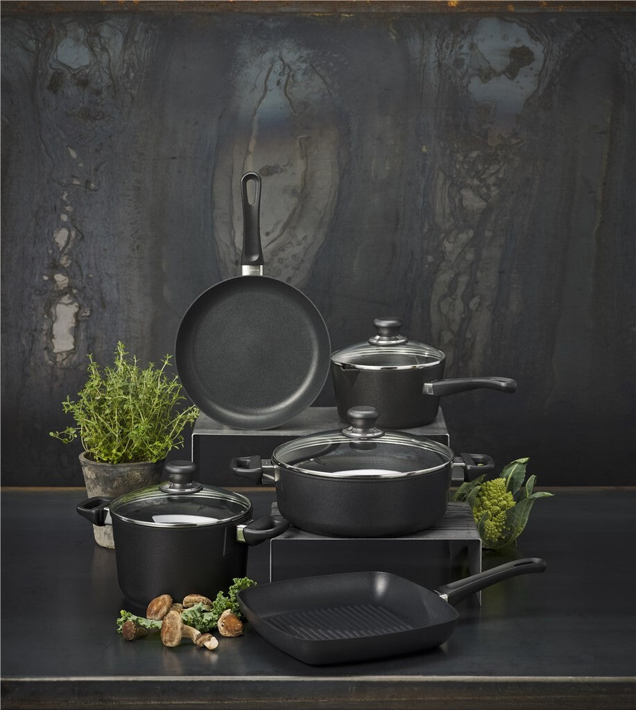 SCANPAN Classic Induction Töpfe und Pfannen vor dunklem Hintergrund arrangiert