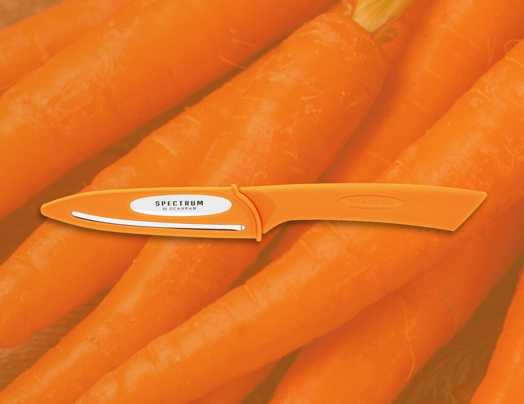 Spectrum vegetable knife in Carrot Curl shown in use